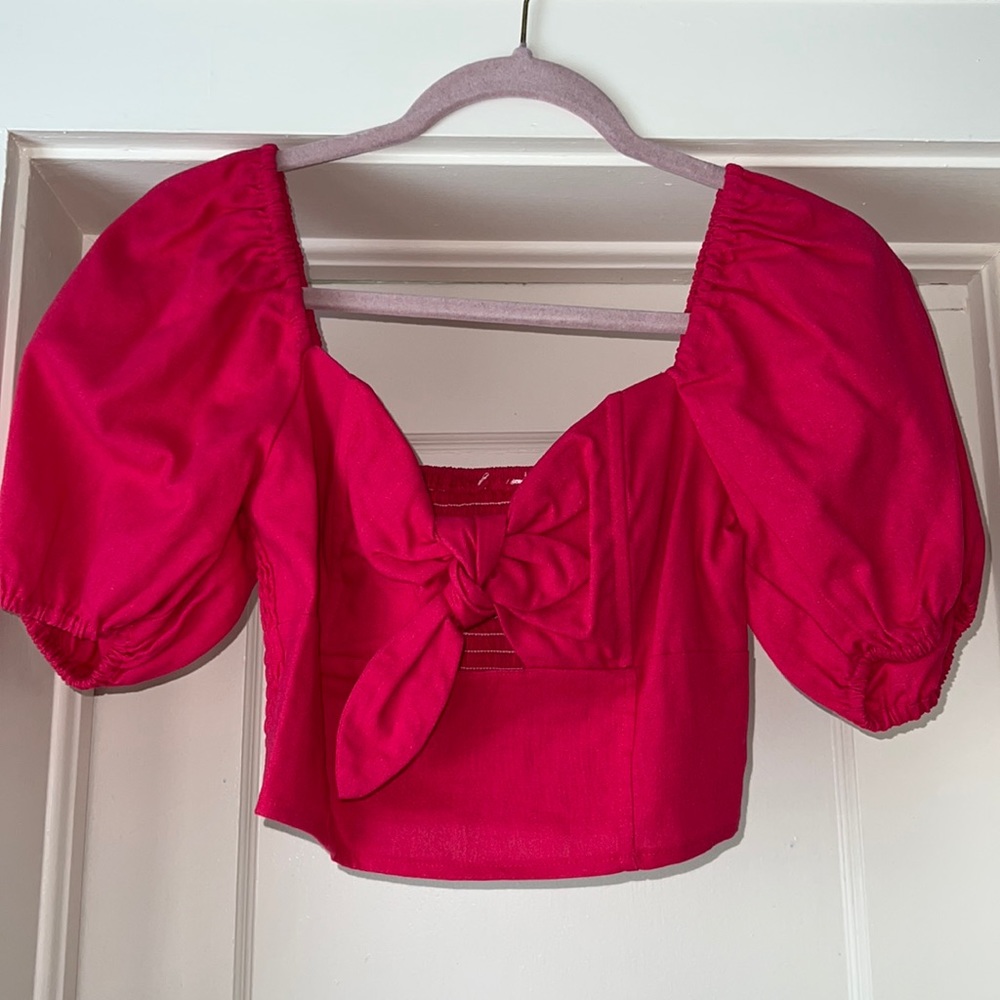 Pink crop top and puff sleeve with tie in front. Size S. Good condition.